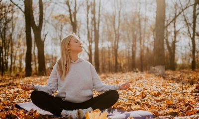girl in autumn forest on yoga mat